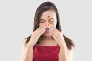 woman in red wear feeling unwell because of sinus pain